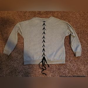 Gray sweater with black criss cross tie detaol